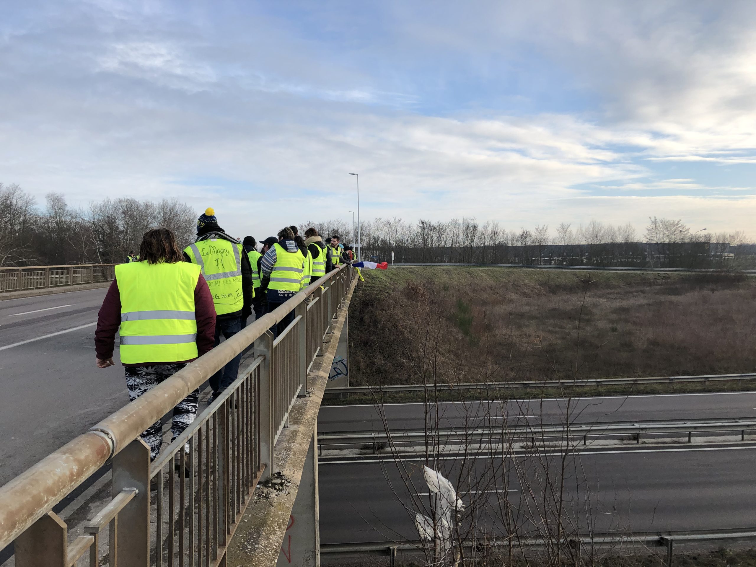 <i>Gilet jaunes</i> on an overpass above a highway